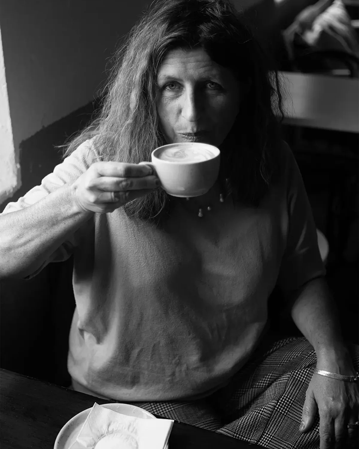 Svartvit bild på Ida som njuter av en cappuccino